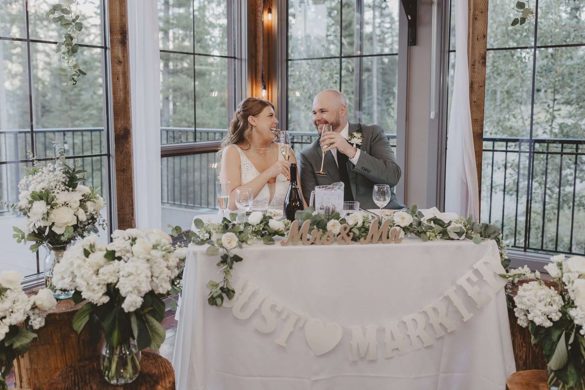 Top Locations Wedding Photography in Alberta | Canmore couple wedding reception clinking glasses